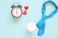 Blue colour necktie, coffee cup and clock on pastel background. Top view, Father`s Day concept