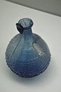 Blue coloured ancient glass juglet with relief ornament made by vegetal and zoomorphic themes