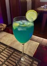 A blue coloured mocktail with lemon