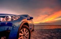 Blue compact SUV car with sport and modern design parked by beach at sunset. Hybrid and electric car technology. Car parking space Royalty Free Stock Photo