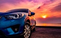 Blue compact SUV car with sport and modern design parked on concrete road by the sea at sunset. Environmentally friendly Royalty Free Stock Photo