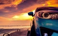 Blue compact SUV car with sport and modern design parked on concrete road by the sea beach at sunset. Front view of luxury car.