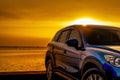 Blue compact SUV car with sport and modern design parked on concrete road by the sea at sunset. Business success concept. Road Royalty Free Stock Photo
