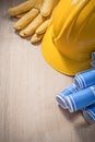 Blue construction plans hard hat leather protective gloves on wo Royalty Free Stock Photo