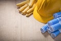 Blue construction plans hard hat safety gloves on wooden board Royalty Free Stock Photo