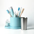 Blue container holds personal hygiene products. Items include toothbrush toothpaste floss comb, metal cup on white surface. This Royalty Free Stock Photo