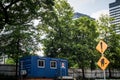 Blue container house as office or house with green tree as background and big building