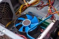 Blue cooler fan with motherboard inside a computer.