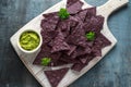 Blue corn Organic tortilla chips with Guacamole on white wooden board Royalty Free Stock Photo