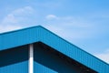 Blue corrugated steel roof with awning of warehouse building against blue sky background Royalty Free Stock Photo