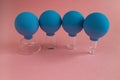Blue cosmetic vacuum jars of different sizes made of glass and rubber on pink background