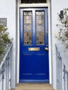 A blue cottage door with a stained glass window.