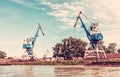 Blue cranes in cargo port, Danube river, red filter