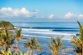 Blue crashing wave in ocean and coconut palms on a beach. Crystal wave in Bali Royalty Free Stock Photo