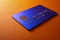 Blue credit card with embedded chip technology resting on a vibrant orange surface symbolizing modern digital payments and secure Royalty Free Stock Photo