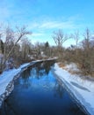 Blue creek water under blue sky in frigid winter season Royalty Free Stock Photo