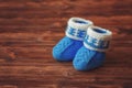 Blue crochet baby booties on wooden background, copyspace, vintage toned Royalty Free Stock Photo