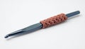 Blue Crochet Hook with Brown Yarn Handle on White Background for Textile Craft Royalty Free Stock Photo