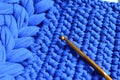 Blue crocheted pattern with a crochet hook, hobby inspiration, crocheted texture background, handmade design Royalty Free Stock Photo