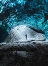 Blue crystal ice cave entrance with tourist climber and an underground river beneath the glacier located in the Royalty Free Stock Photo