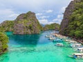 Blue crystal water in paradise Bay with boats on the wooden pier at Kayangan Lake in Coron island, Palawan, Philippines Royalty Free Stock Photo