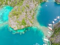 Blue crystal water in paradise Bay with boats on the wooden pier at Kayangan Lake in Coron island, Palawan, Philippines Royalty Free Stock Photo