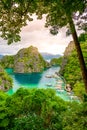 Blue crystal water in paradise Bay with boats on the wooden pier at Kayangan Lake in Coron island, Palawan, Philippines Royalty Free Stock Photo