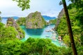 Blue crystal water in paradise Bay with boats on the wooden pier at Kayangan Lake in Coron island, Palawan, Philippines Royalty Free Stock Photo