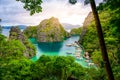 Blue crystal water in paradise Bay with boats on the wooden pier at Kayangan Lake in Coron island, Palawan, Philippines Royalty Free Stock Photo