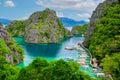 Blue crystal water in paradise Bay with boats on the wooden pier at Kayangan Lake in Coron island, Palawan, Philippines Royalty Free Stock Photo