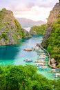 Blue crystal water in paradise Bay with boats on the wooden pier at Kayangan Lake in Coron island, Palawan, Philippines