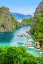 Blue crystal water in paradise Bay with boats on the wooden pier at Kayangan Lake in Coron island, Palawan, Philippines Royalty Free Stock Photo