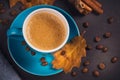 Blue cup of coffee with coffee beans and autumnal dry leaves Royalty Free Stock Photo