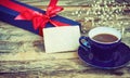 Blue cup of coffee, gift box with red ribbon Royalty Free Stock Photo