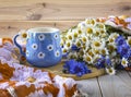 A blue cup with daisies and a beautiful bouquet of daisies and cornflowers. Summer still life with wild flowers Royalty Free Stock Photo