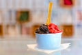 Blue cup of dark chocholate and raspberry ice cream in shop on a table