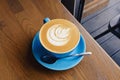 Blue cup of fresh cappuccino with latte art Royalty Free Stock Photo