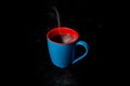 A Blue Cup of hot Steaming coffee black background Royalty Free Stock Photo