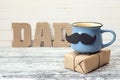 Blue cup with a mustache, gift box and an inscription Dad in the