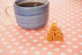 Blue cup of tea and lump sugar on pink background Royalty Free Stock Photo