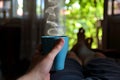 Tranquil Retreat: Man Relishing a Steaming Cup of Tea in Bed on a Sunny Summer Day