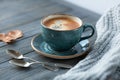 Blue cup whith coffee, knitted sweater, autumn leaves on wooden background.