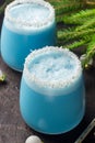 Blue curacao Christmas Cocktail, garnished with coconut on Christmas decorated holiday table with Christmas ornaments. Holiday Royalty Free Stock Photo