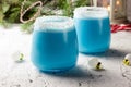 Blue curacao Christmas Cocktail, garnished with coconut on Christmas decorated holiday table with Christmas ornaments. Holiday Royalty Free Stock Photo