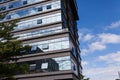 Blue curtain wall made of toned glass and steel constructions under cloudy sky Royalty Free Stock Photo