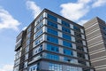 Blue curtain wall made of toned glass and steel constructions under cloudy sky Royalty Free Stock Photo