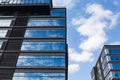 Blue curtain wall made of toned glass and steel constructions under cloudy sky Royalty Free Stock Photo