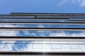 Blue curtain wall made of toned glass and steel constructions under cloudy sky Royalty Free Stock Photo