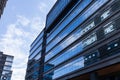 Blue curtain wall made of toned glass and steel constructions under cloudy sky Royalty Free Stock Photo