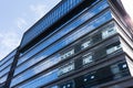 Blue curtain wall made of toned glass and steel constructions under cloudy sky Royalty Free Stock Photo